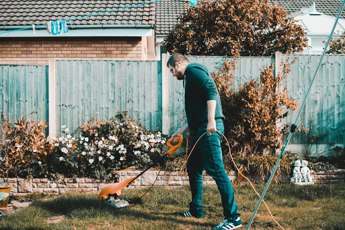 Landscaping worker trimming a residential lawn